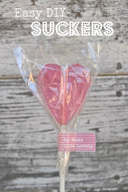 a pink lollipop with the words easy diy suckers on it in front of a wooden background