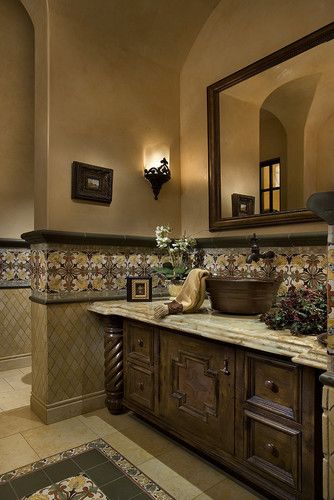 a bathroom with a sink, mirror and tiled walls in the background is an ornately decorated bathtub