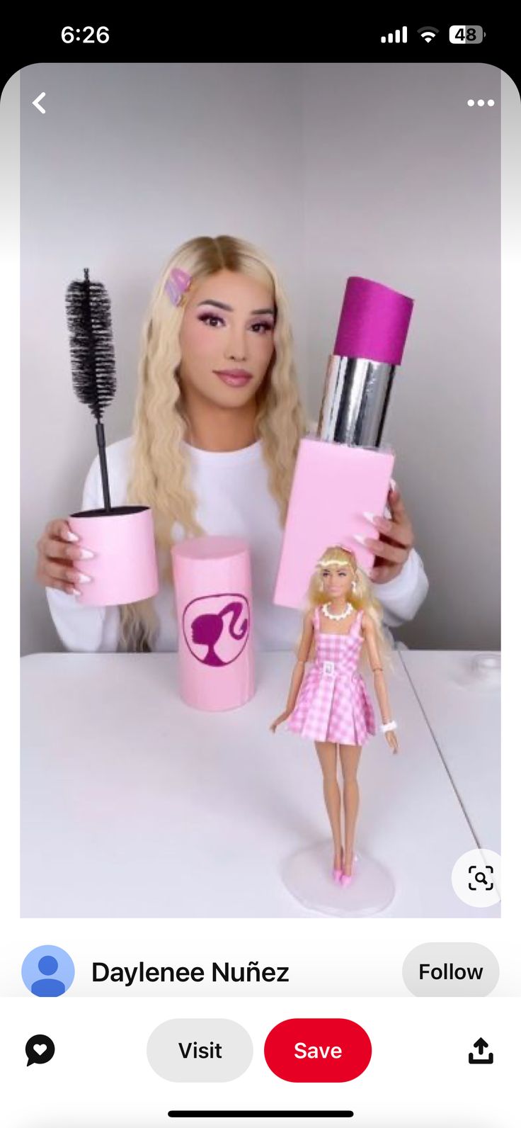 the barbie doll is holding two hairbrushes in her hands and one has a pink cup