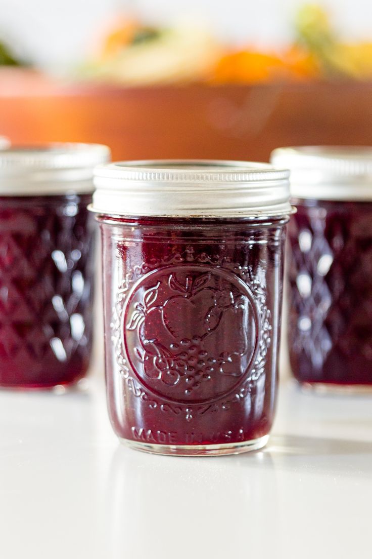 three jars filled with jam sitting on top of a table