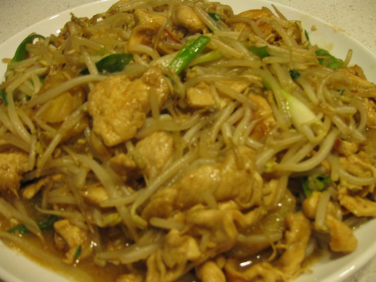 a white plate topped with noodles and meat