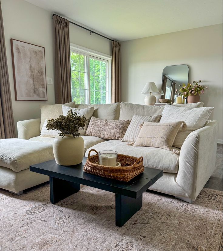 a living room with a couch, coffee table and mirror in the corner on the wall