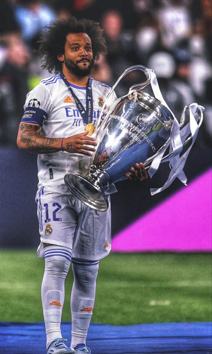 a man holding a soccer trophy on top of a field