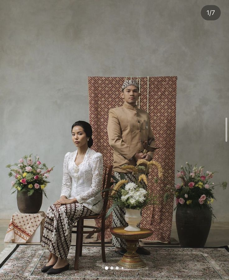 a woman sitting in a chair next to a man with a crown on his head