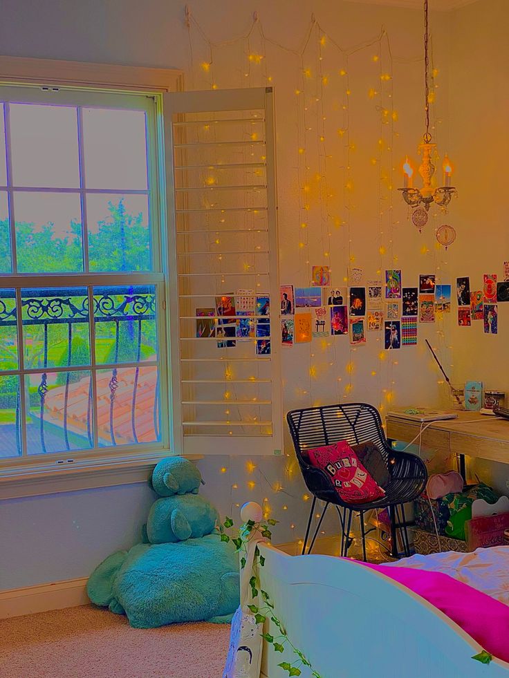 a bedroom decorated in pastel colors with lights strung from the ceiling and pictures on the wall