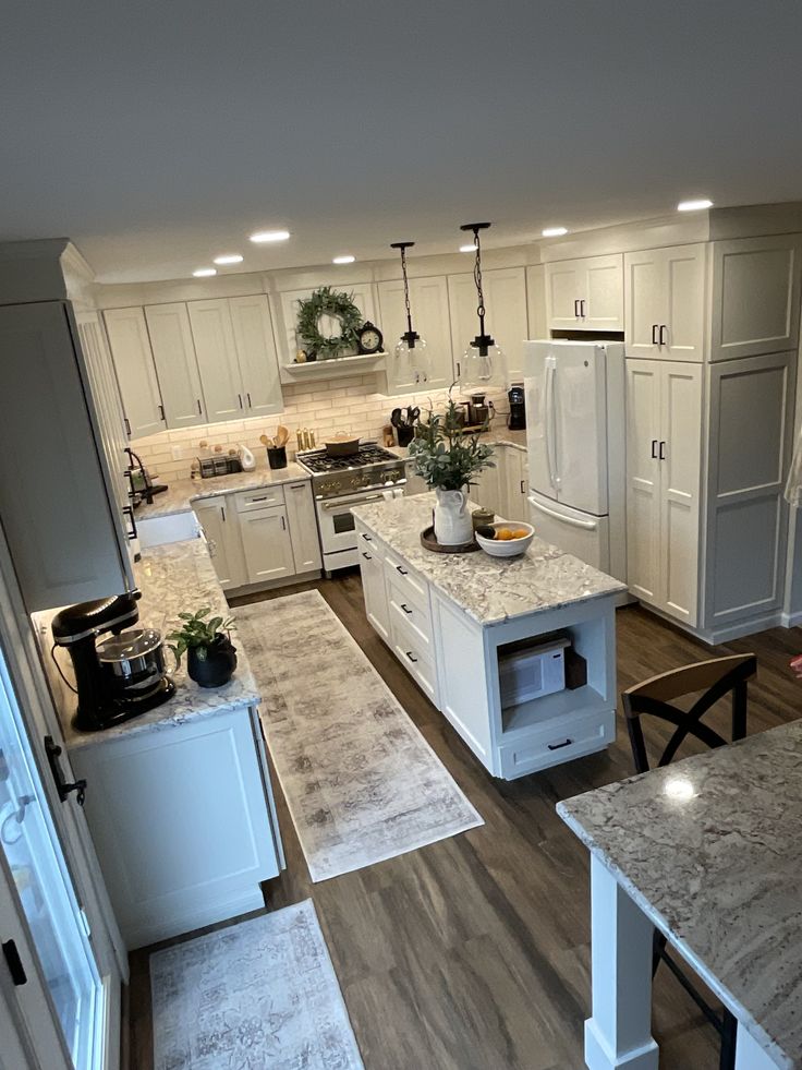 a large kitchen with white cabinets and granite counter tops, along with an island in the middle