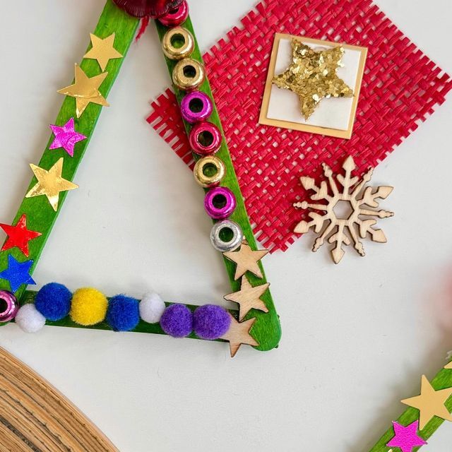 a christmas tree made out of construction paper and other crafting supplies on a table