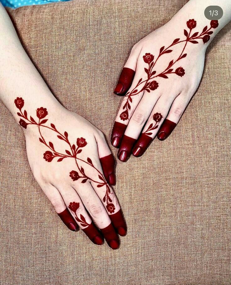 two hands with hendi designs on them, one is red and the other is white