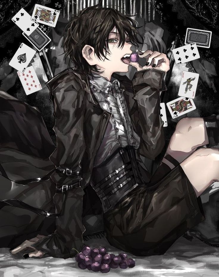 a person sitting on the ground with some cards and grapes in front of them,