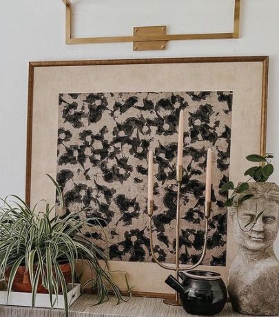 there is a painting on the wall next to a potted plant