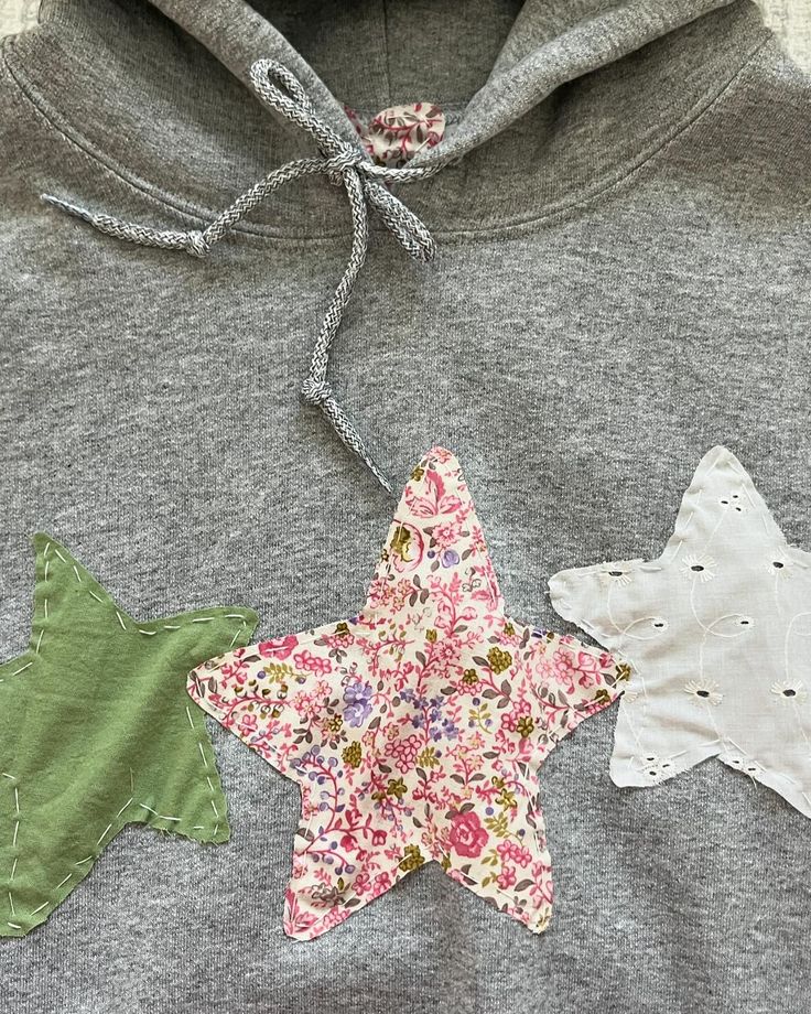 three star shaped appliques are attached to a hoodie