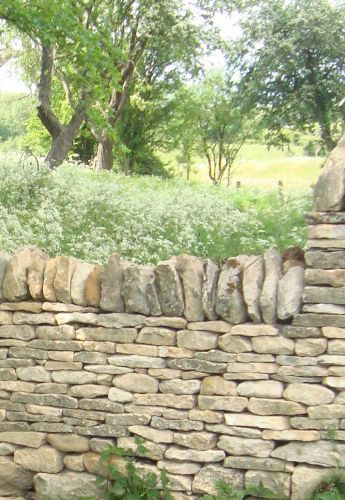 there is a stone wall that has been built into the ground with rocks on it