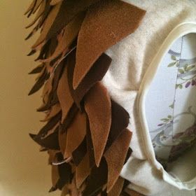 a close up of a decorative piece of cloth on a chair with feathers attached to it