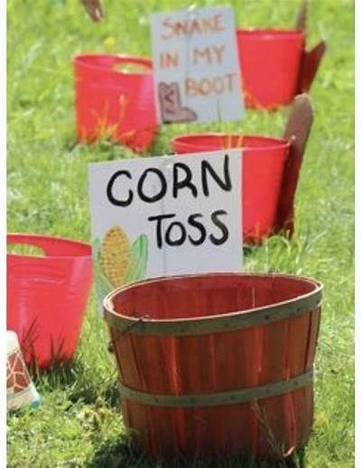 several red buckets with corn tots on them sitting in the grass next to a sign that says corn tots