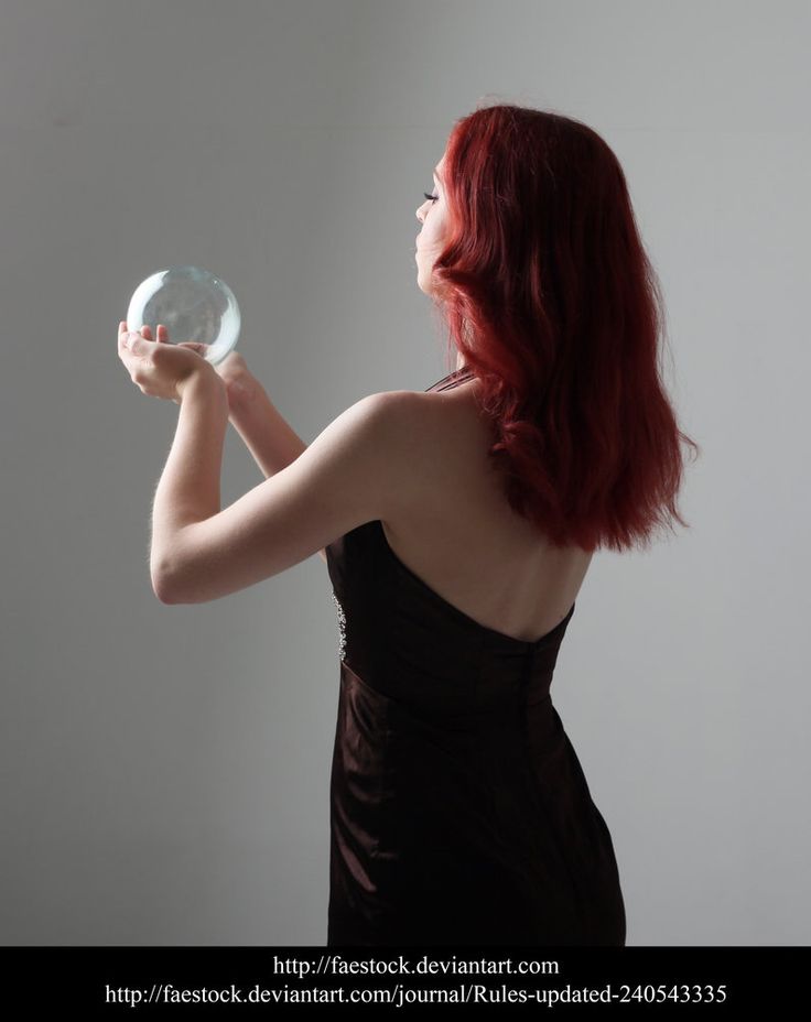 a woman with red hair is holding a white object in her hand and looking up