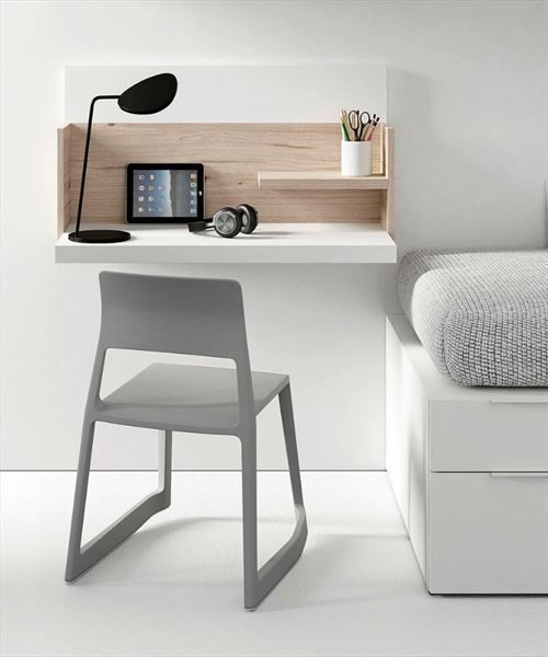 a white bed sitting next to a desk with a computer on it