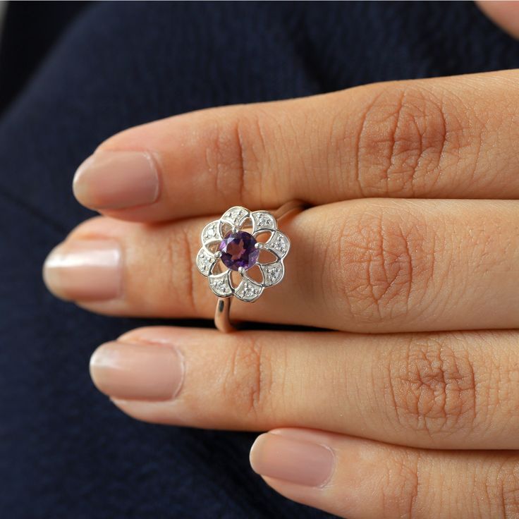 Sometimes when a girl says she likes to receive flowers as a gift, it's not the real flowers she meant. Think twice and go for the safest thing - our Flora ring with amethyst and side Moissanites. Floral jewelry is where it's at! Perfect as a graduation gift, birthday gift, anniversary ring, or a promise ring. Details: Center stone Gemstone: Amethyst Stone Shape: Round Measurements: 5.00mm Side stones Gemstone: Moissanite Shape: Round Measurements: 1.30mm (8) Band measurements: approx. 1.8mm wid Purple Diamond Ring With Rose Cut For Gift, Purple Rose Cut Diamond Ring As A Gift, Flower Ring With Rose Cut Diamonds For Gifts, Flower Shaped Diamond Ring For Anniversary, Flower Shaped Wedding Rings For Valentine's Day, Diamond Flower Ring With Birthstone As A Gift, Diamond Flower Ring With Halo Design For Gift, Diamond Flower Ring With Halo Design As Gift, Flower Shaped Rings With Rose Cut Diamonds For Gift