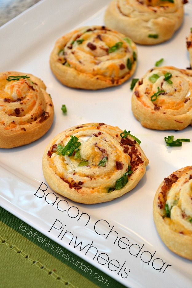 some tasty looking appetizers are on a white platter with green napkins