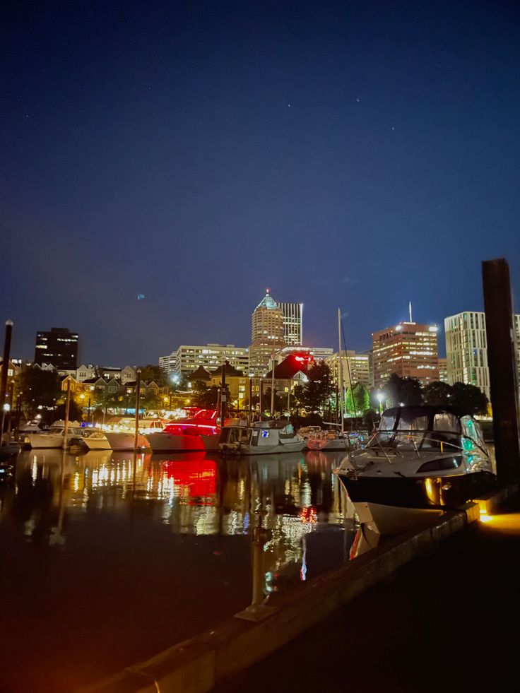 boats are docked in the harbor at night