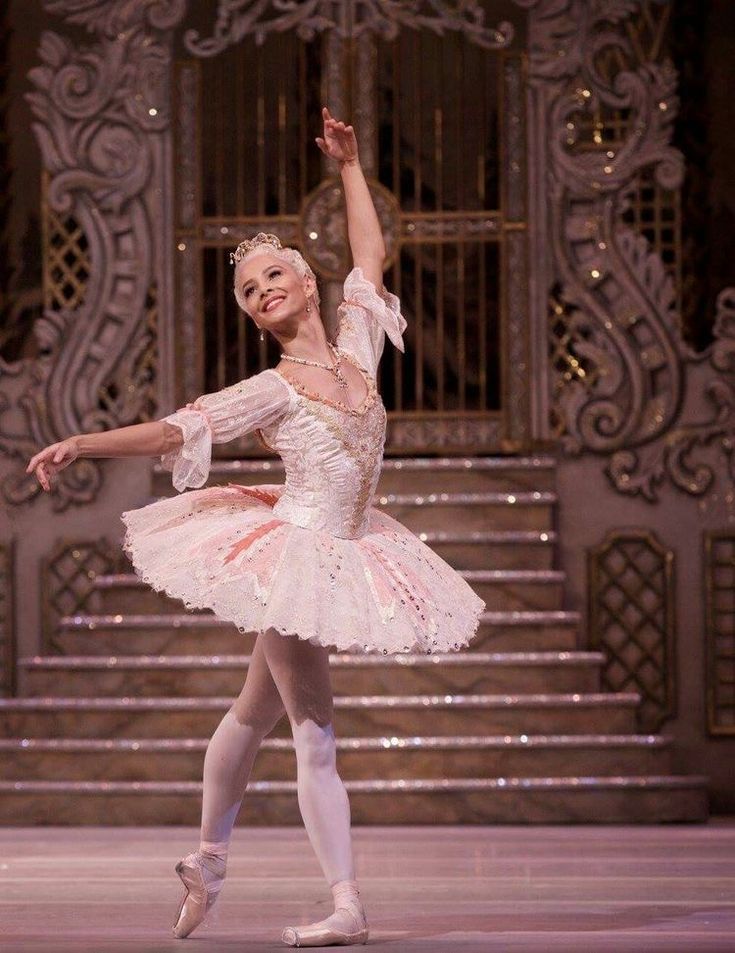 the ballerina is dressed in pink and white