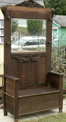 an old wooden bench with a mirror on it