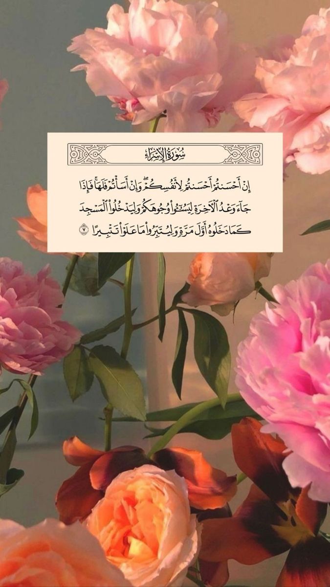 pink and white flowers are in front of a card with an arabic writing on it