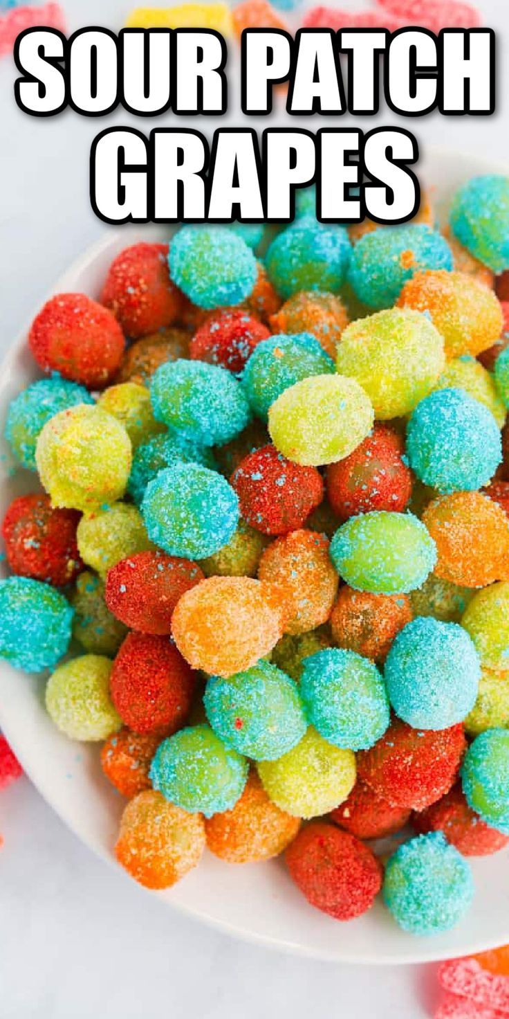 a white bowl filled with rainbow colored soury patch grapes on top of a table