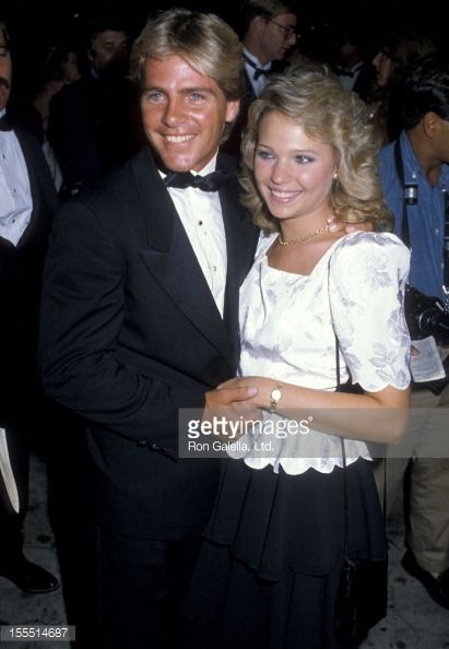 a man in a tuxedo standing next to a woman wearing a white dress