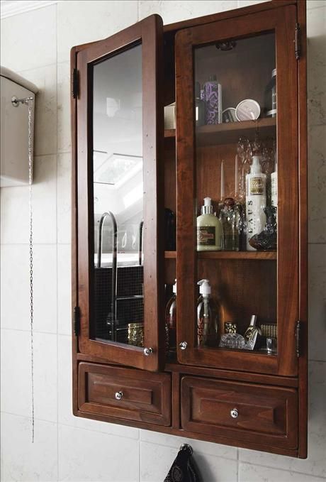 a wooden medicine cabinet sitting next to a white tiled wall