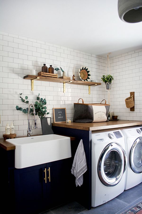 a washer and dryer in a room with white bricks on the wall behind them