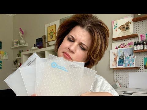 a woman is holding three envelopes in her hands and looking at the paper on top