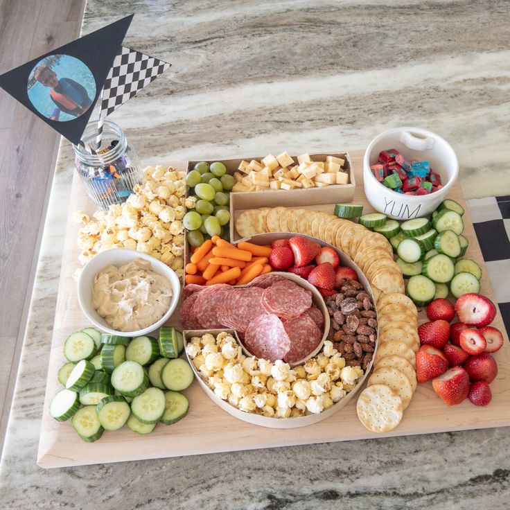 a platter filled with meat, vegetables and crackers