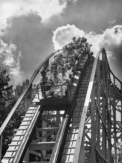 people ride the roller coaster at an amusement park