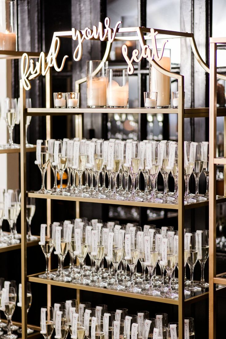 wine glasses are lined up on a shelf with the words find your seat next to them