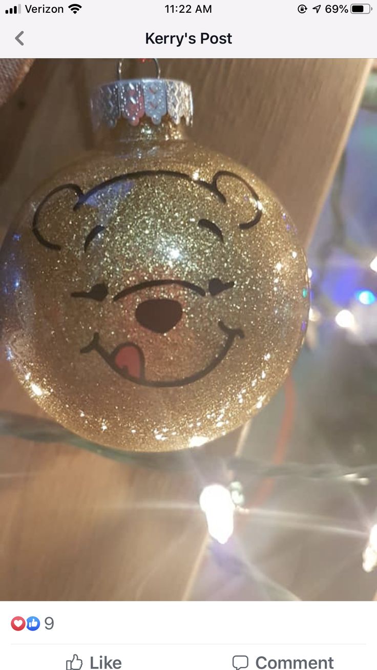 a gold ornament with a bear face drawn on it's front and side