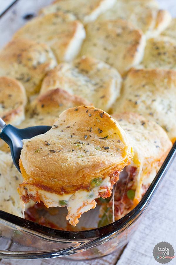 a casserole dish with meat and cheese being lifted from the casserole