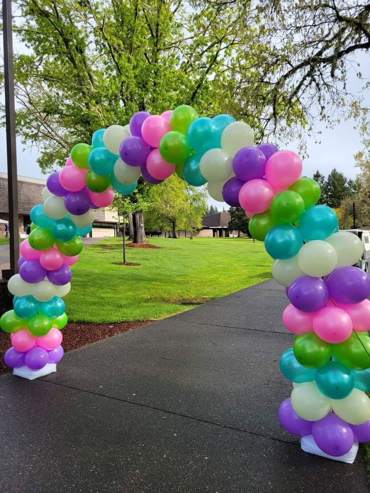 an arch made out of balloons on the sidewalk