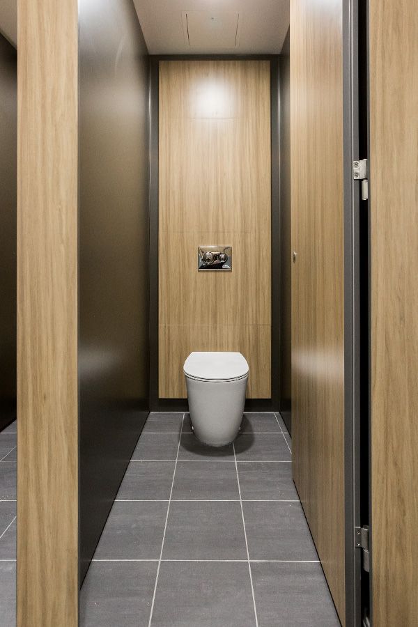 an empty toilet is in the middle of a bathroom with wood paneling on the walls