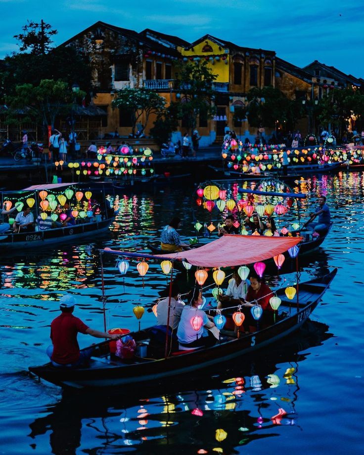 several boats with lanterns floating on the water