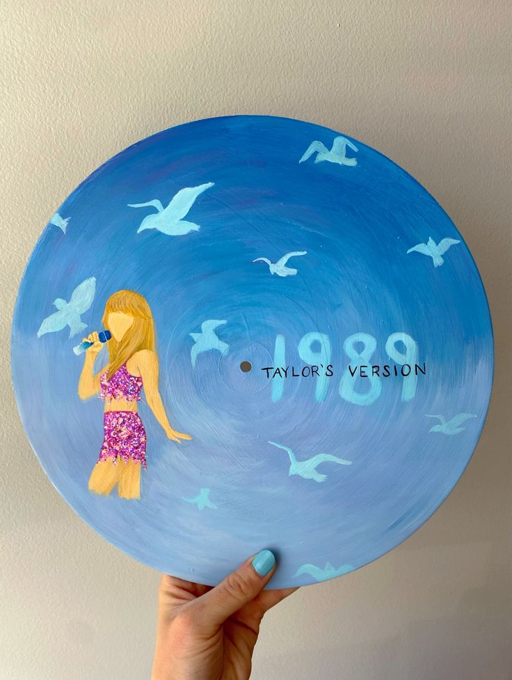 a person holding up a blue plate with a girl on it and birds flying around