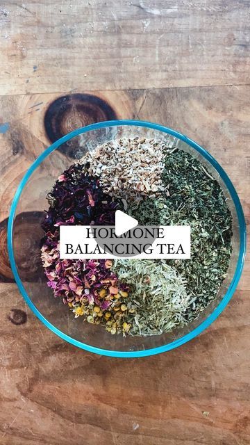 a bowl filled with lots of different types of herbs on top of a wooden table