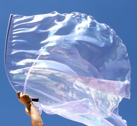 a person holding a large plastic bag in the air with blue sky behind them and white clouds