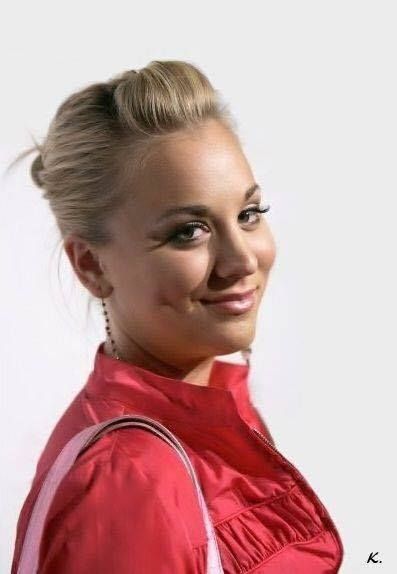 a woman with blonde hair wearing a red shirt and smiling at the camera, in front of a white background