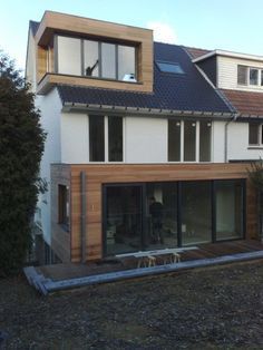 a house that has some windows on the side of it and is made out of wood