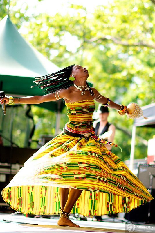 a woman in a colorful dress dancing on stage