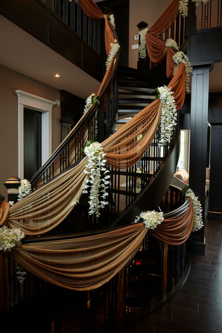 an elegant staircase decorated with flowers and ribbons