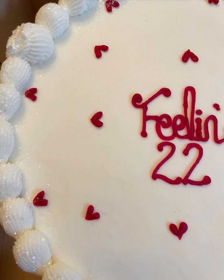 a white cake with red frosting and the words feeling 22 written on it's side