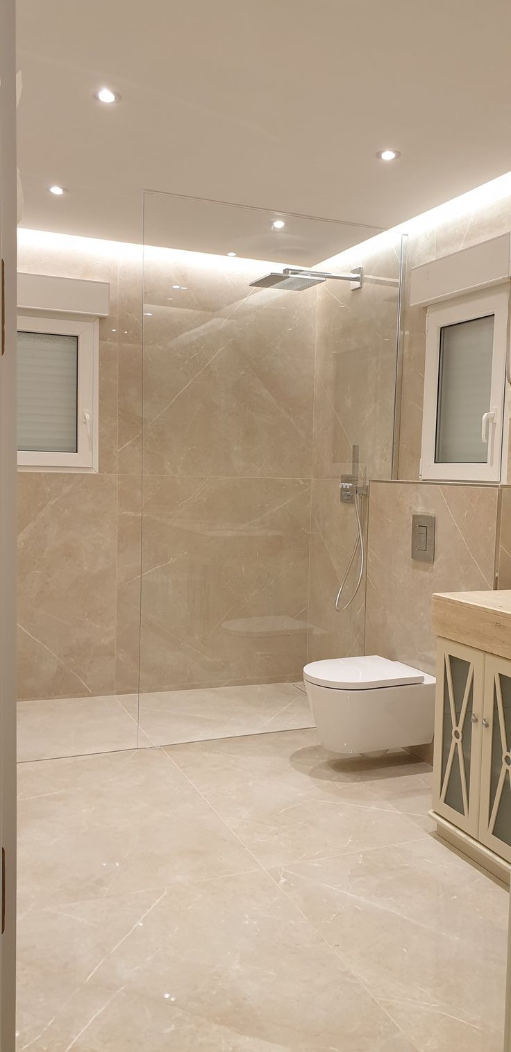 a bathroom with a sink, toilet and shower stall in the middle of the room