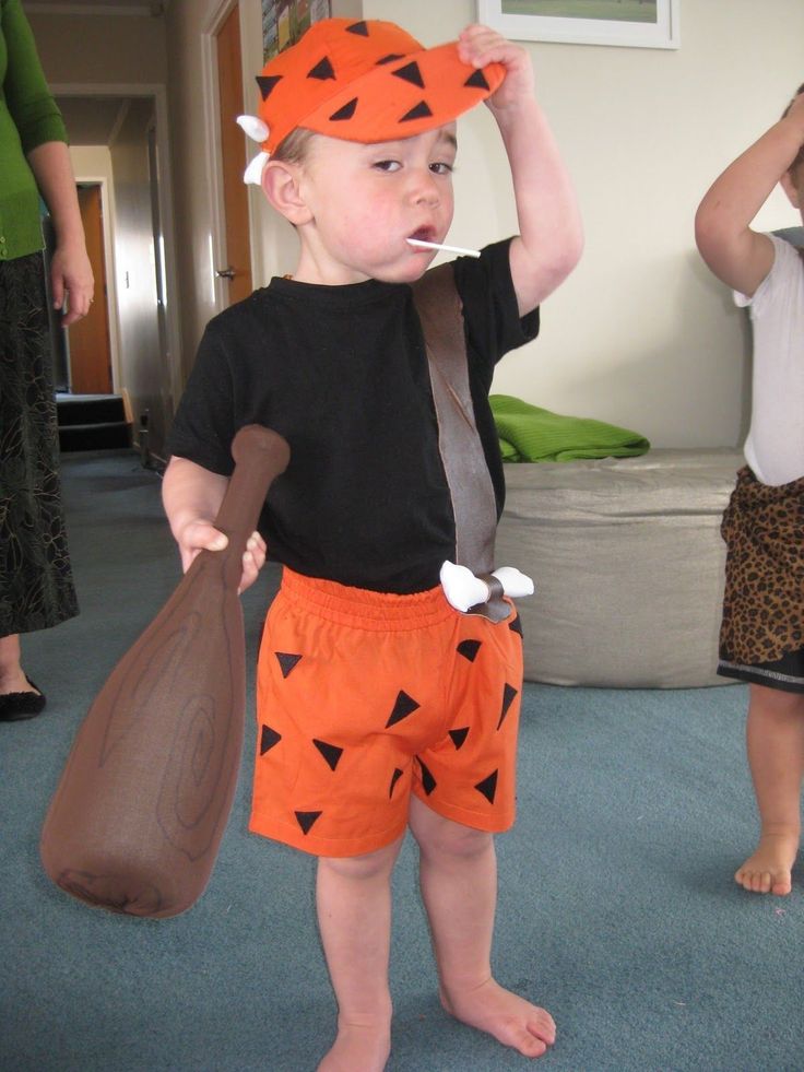 a young boy wearing an orange and black costume