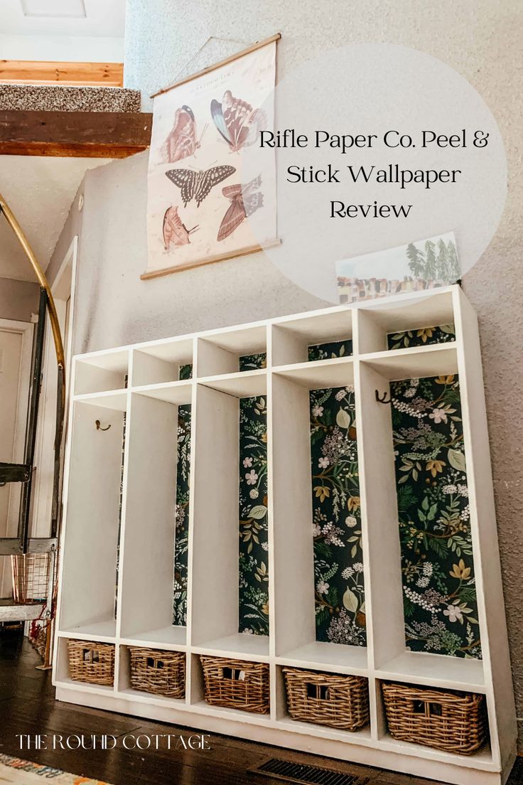 a white shelf with baskets and wallpaper on it